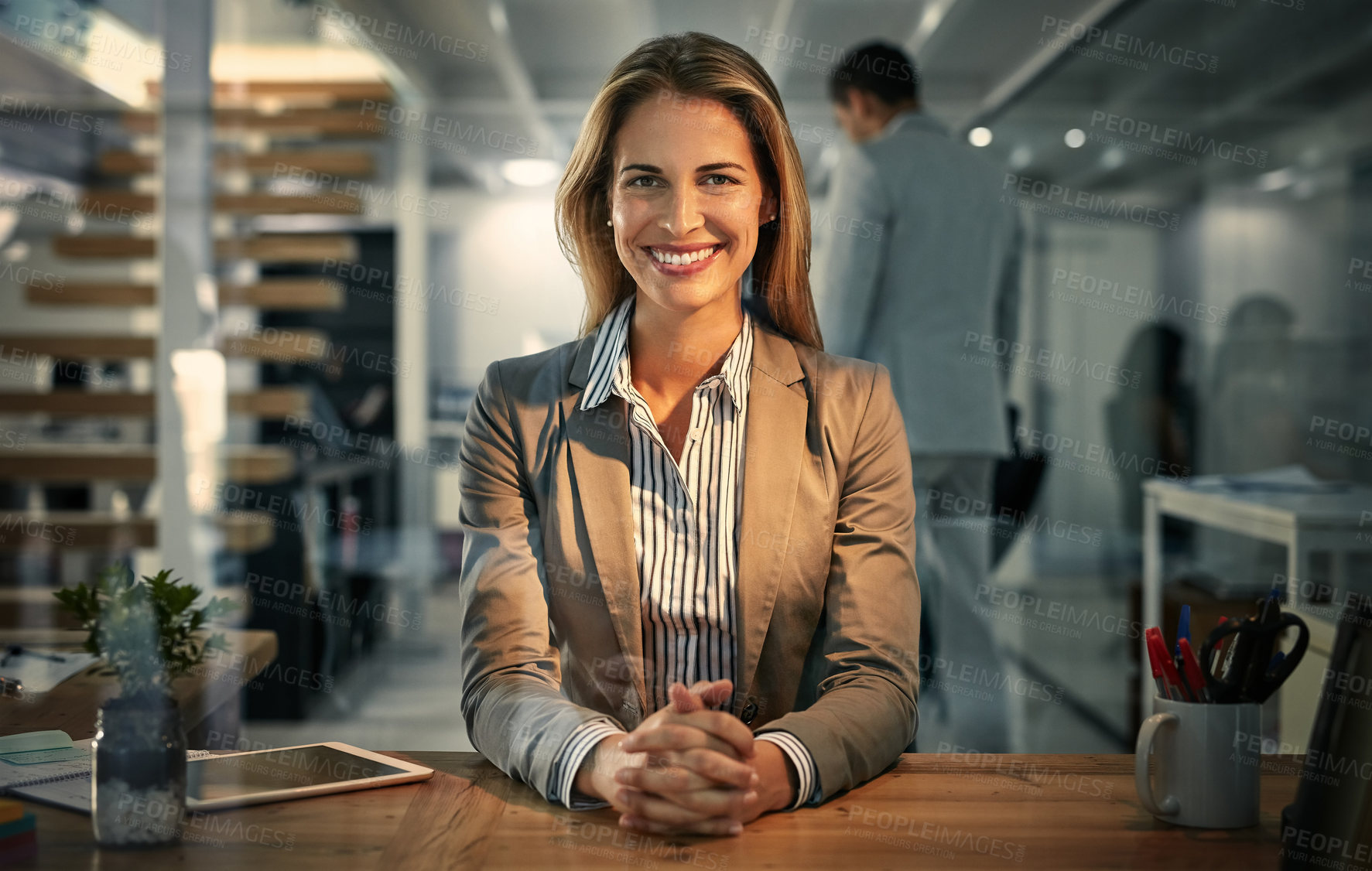 Buy stock photo Portrait, business and woman at desk, hands together and career ambition in modern office. Night, face and employee with confidence, tablet and internet with pride, corporate and professional