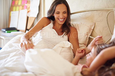 Buy stock photo Shot of a happy little girl lying in bed with her dad and pregnant mother