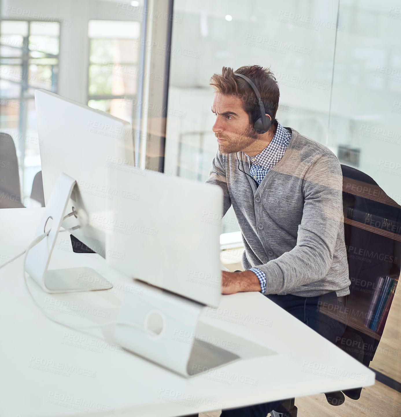 Buy stock photo Office, monitor and serious businessman with headphones for audio, streaming and listening to music. Male person, administration and work with technology for portfolio research, report and feedback