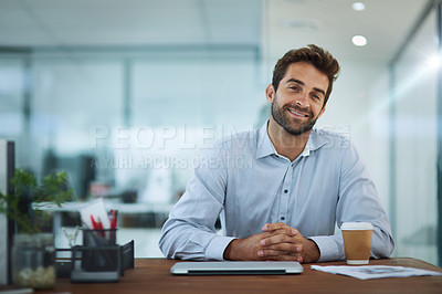 Buy stock photo Portrait of a young corporate businessman sitting at a desk in an office