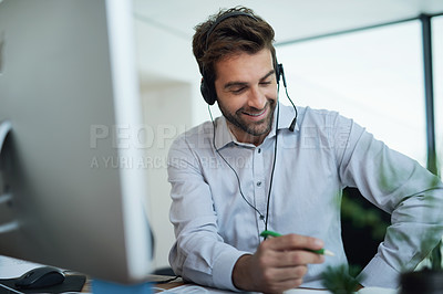Buy stock photo Shot of a young corporate businessman using a headset in an office
