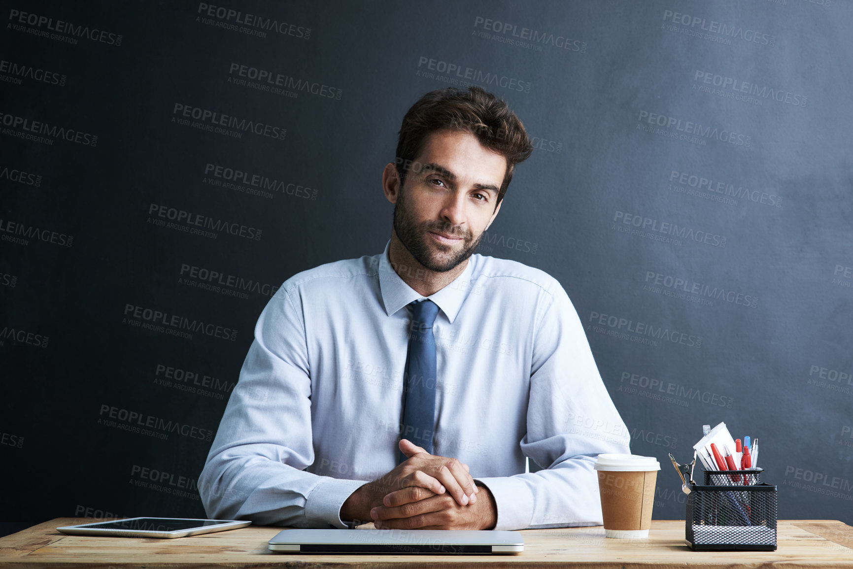 Buy stock photo Businessman, portrait and desk with wall background at laptop at insurance broker, investment or finance. Male person, face and confidence with stationery at table or loan, connectivity or mockup