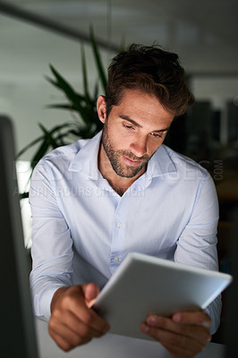 Buy stock photo Shot of a young businessman working late at the office 