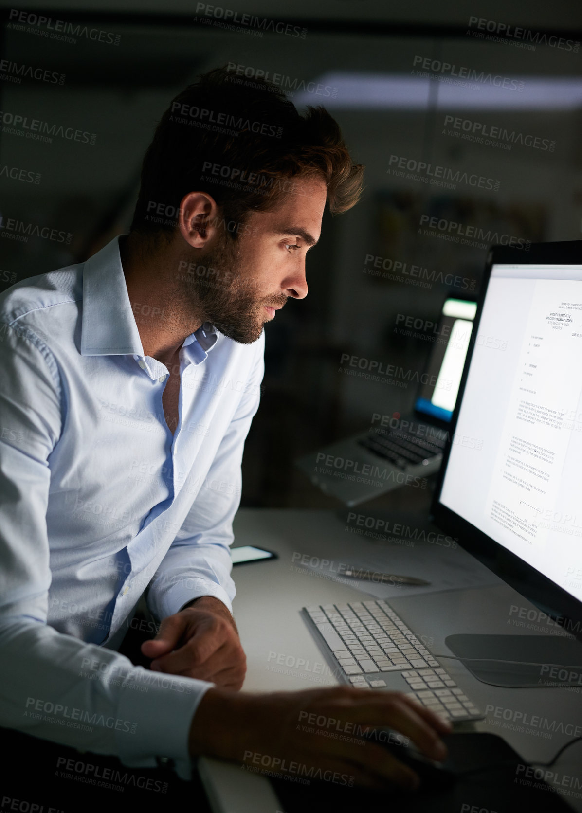 Buy stock photo Shot of a young businessman working late at the office 