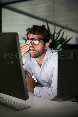 Buy stock photo Shot of a young businessman working late at the office 