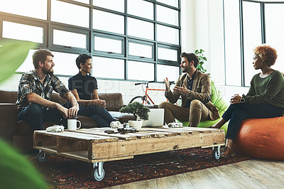 Buy stock photo Shot of a group of young designers having a discussion in a modern office
