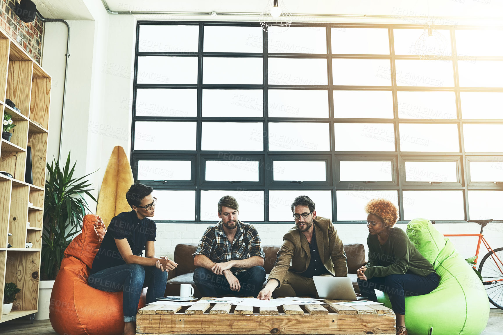 Buy stock photo Shot of a group of young designers discussing paperwork