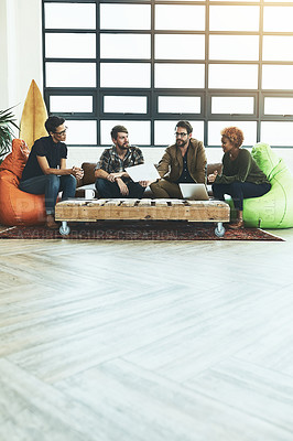 Buy stock photo Shot of a group of young designers discussing paperwork