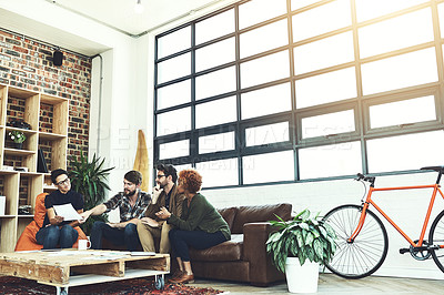 Buy stock photo Shot of a group of young designers discussing paperwork