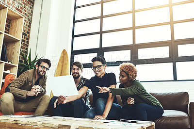 Buy stock photo Shot of a group of young designers discussing paperwork