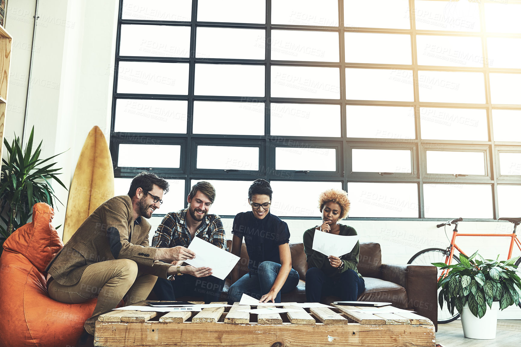 Buy stock photo Shot of a group of young designers discussing paperwork