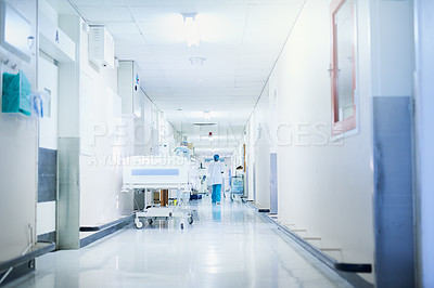 Buy stock photo Rearview shot of a surgeon walking down a hospital corridor
