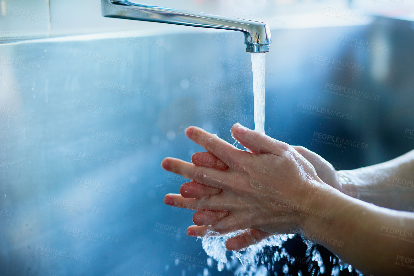 Buy stock photo Cropped shot of a surgeon sterilizing her hands as part of a surgical routine