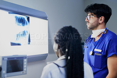 Buy stock photo Shot of a team of surgeons discussing a patient’s x rays during surgery