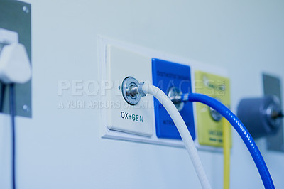 Buy stock photo Shot of tubes connected to an oxygen supply mounted against a hospital wall