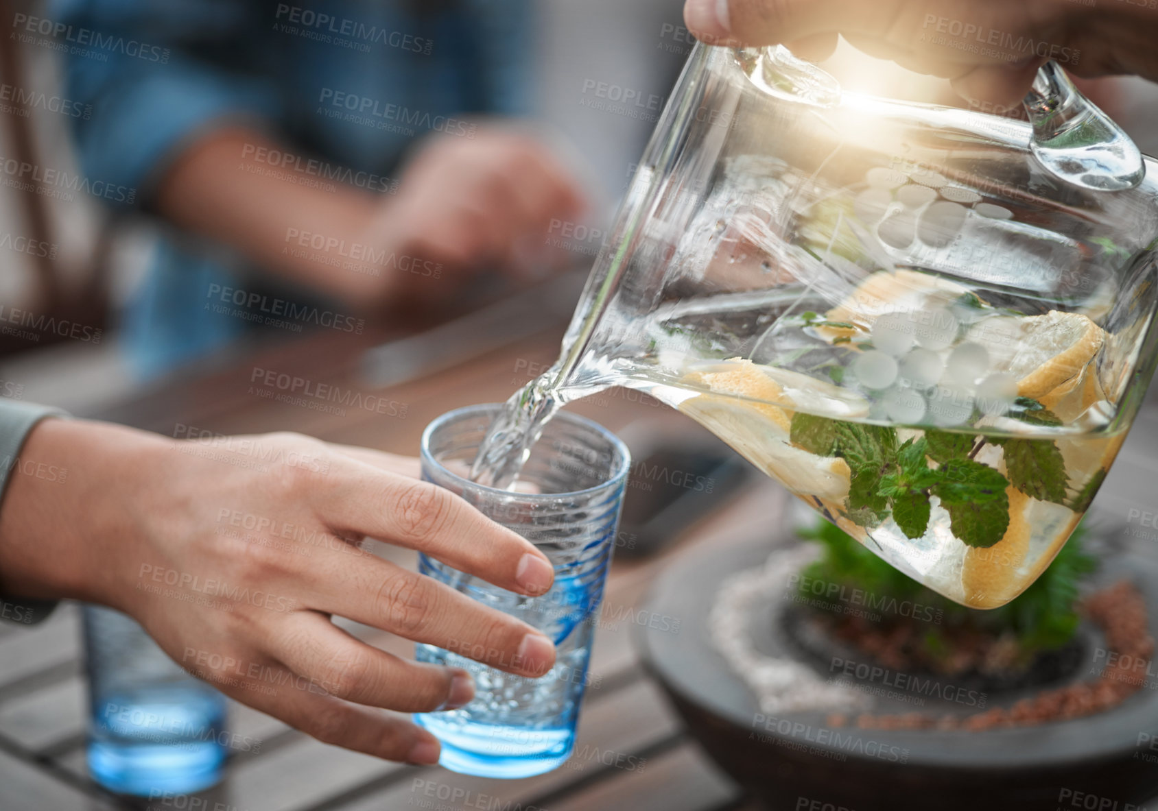 Buy stock photo Hands, closeup and water into a glass, outdoor and social gathering with friends, drink and cool down. Zoom, people and friends with clear liquid, ice and lunch with fresh mint, lemon and natural