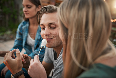 Buy stock photo Eating, feeding and marshmallow with couple at party together for barbecue, celebration or love. Smile, flirting or food with happy man and woman outdoor for bonding, relationship or romance