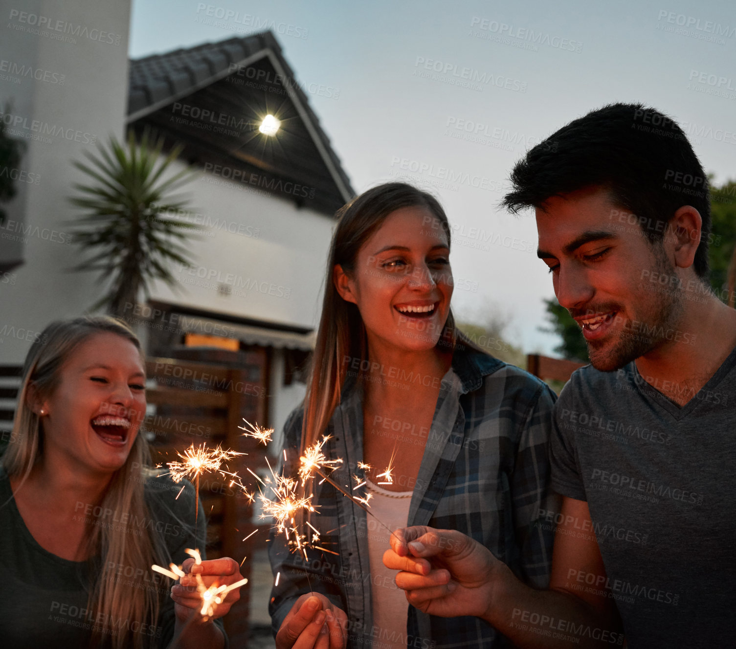 Buy stock photo Happy, group and people with sparkle outdoor for celebration, care and success of new years party at night. Smile, friends and fireworks with flame glow, announcement and achievement memory at house