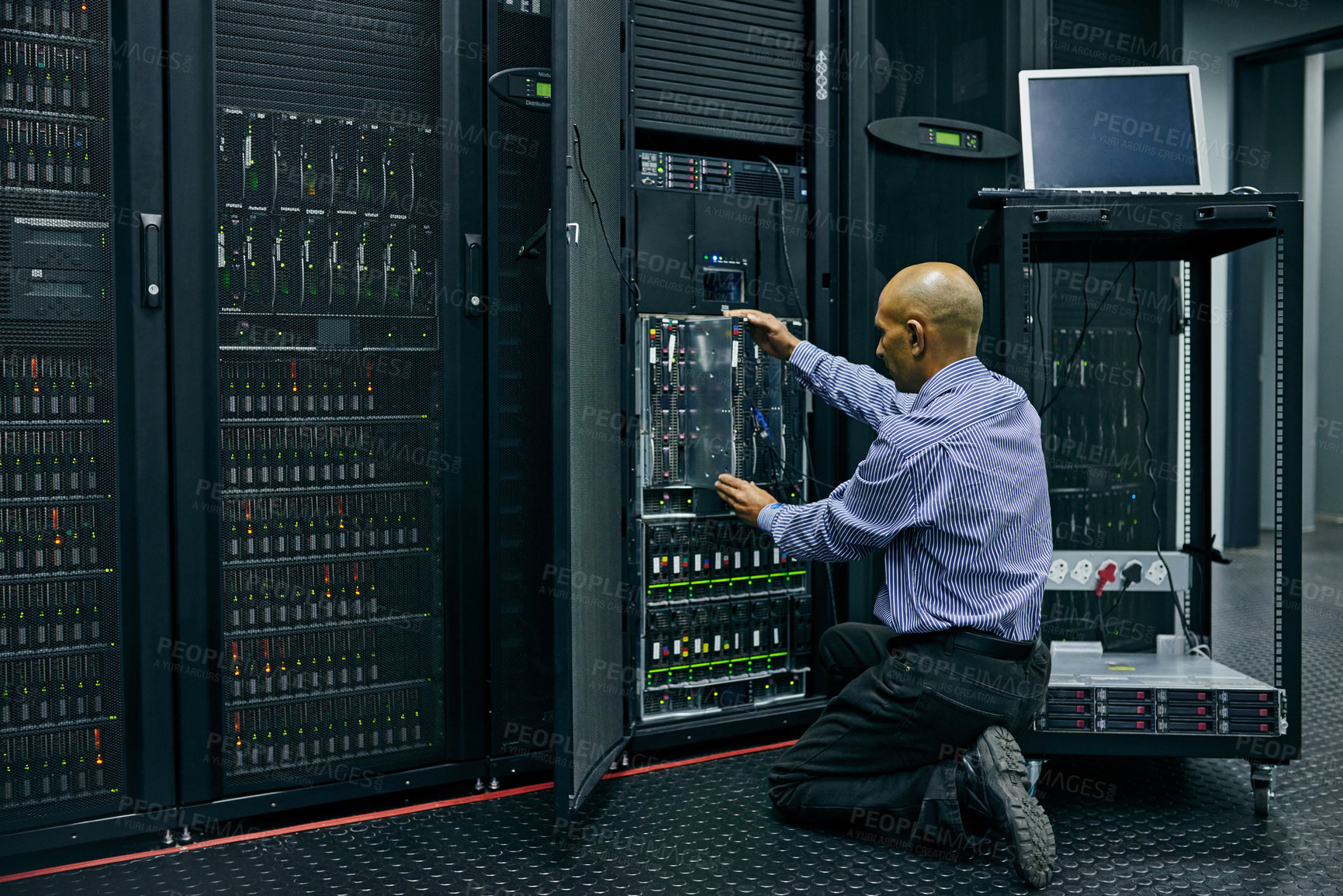 Buy stock photo Database, software and a man engineer in a server room for cybersecurity maintenance on storage hardware. Computer network or mainframe with a technician working on information technology equipment