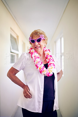 Buy stock photo Shot of a carefree elderly woman wearing pink glasses and posing inside of a building