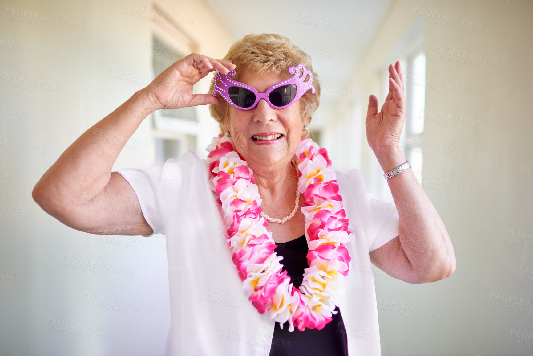 Buy stock photo Shot of a carefree elderly woman wearing pink glasses and posing inside of a building