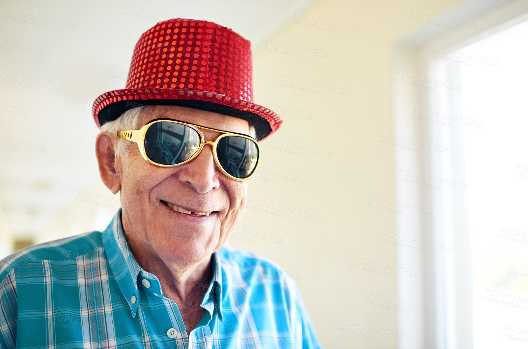Buy stock photo Shot of a carefree elderly man wearing sunglasses and a hat inside of a building