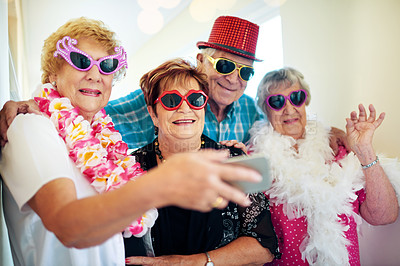 Buy stock photo Shot of a group carefree elderly people wearing glasses and looking at the camera inside of a building