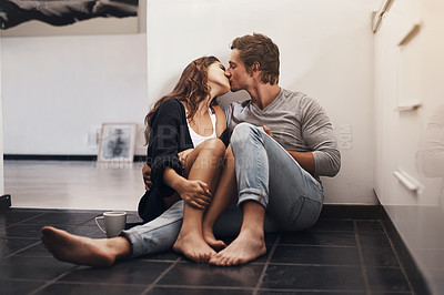 Buy stock photo Kiss, man and woman on kitchen floor with coffee, morning bonding together and love in home with smile. Romance, relax and couple embrace in apartment with care, connection and affection on weekend