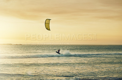 Buy stock photo Rearview shot of a young woman kitesurfing at the beach
