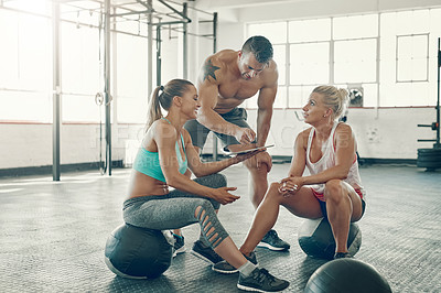 Buy stock photo Shot of a group of young people using a digital tablet at the gym