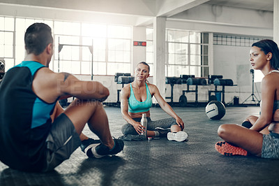 Buy stock photo Shot of a group of young people taking a break together after a workout at the gym