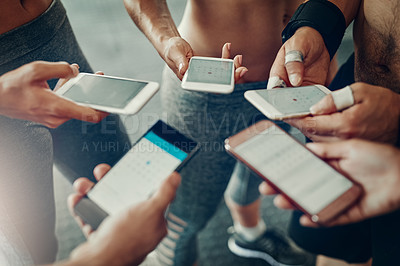 Buy stock photo Closeup shot of a group of people using their cellphones together at the gym