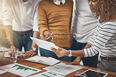 Buy stock photo Shot of a group of colleagues discussing something on a digital tablet