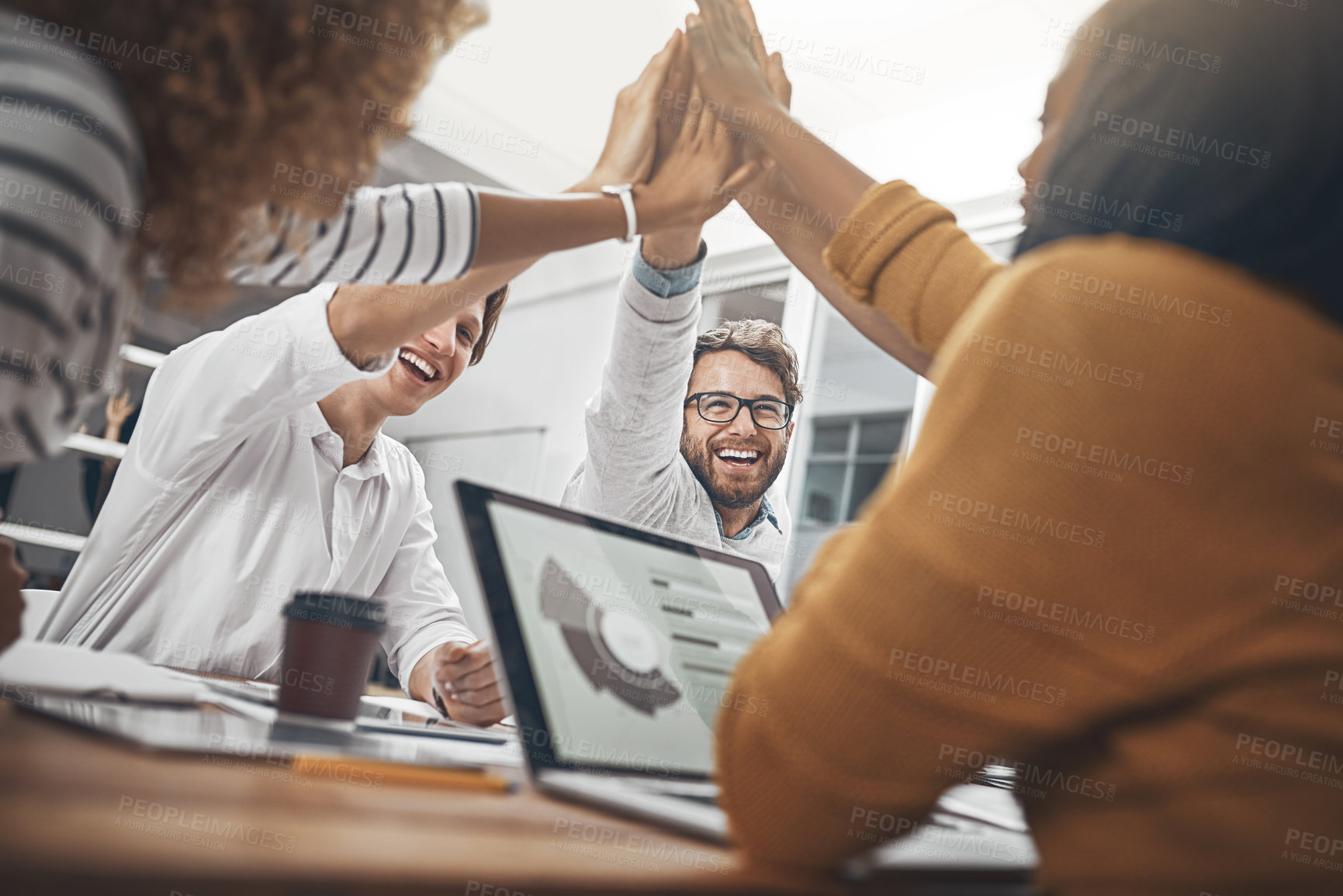 Buy stock photo Shot of colleagues high-fiving in the office