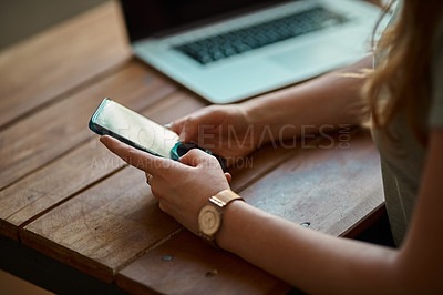 Buy stock photo Cropped shot of an unrecognizable woman using her cellphone
