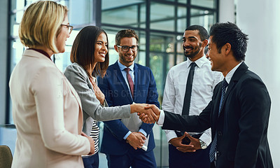 Buy stock photo Shot of businesspeople shaking hands in an office