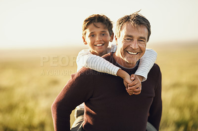 Buy stock photo Shot of a mature man carrying his son on his back