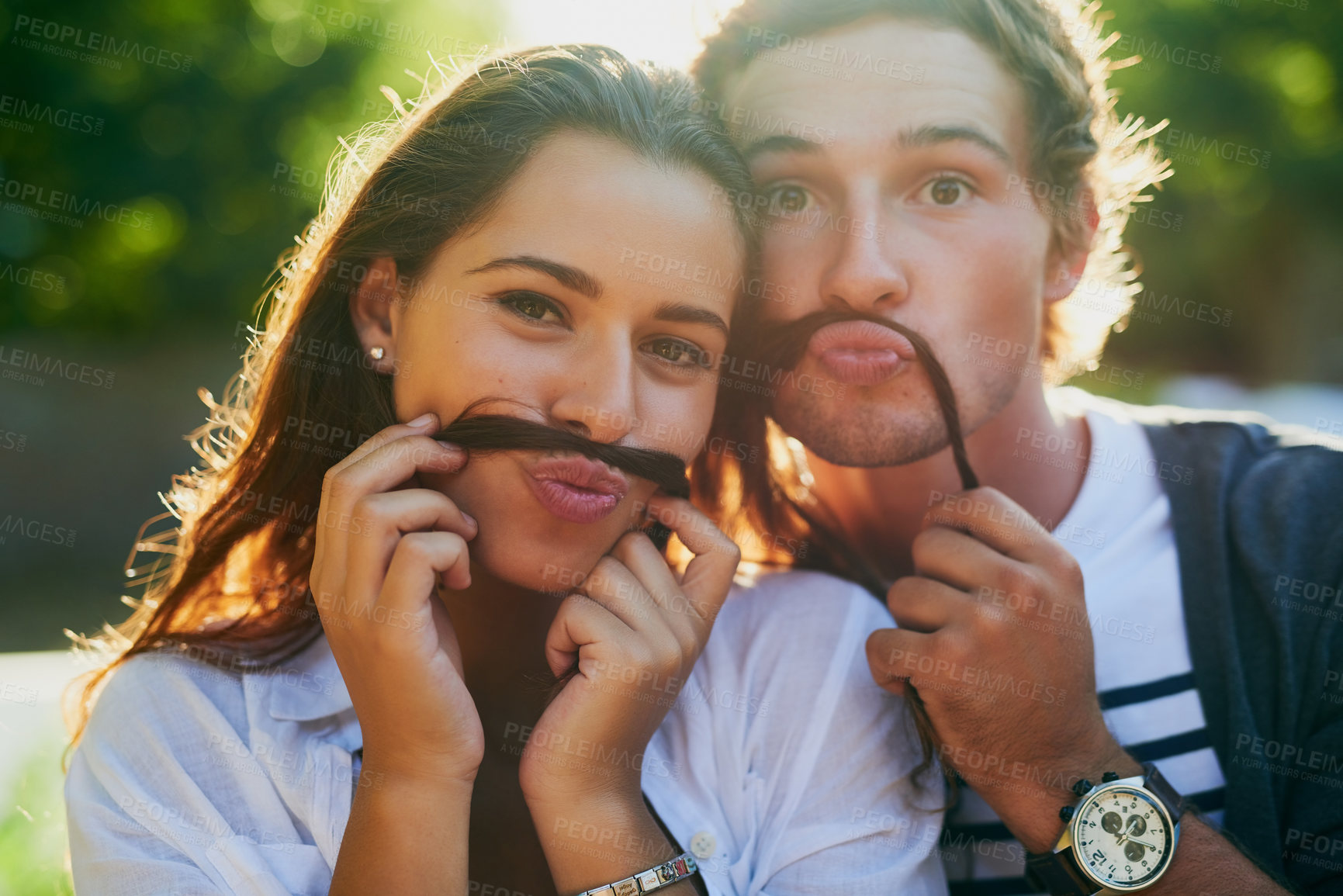 Buy stock photo Portrait of a young couple enjoying a silly moment together while bonding outdoors