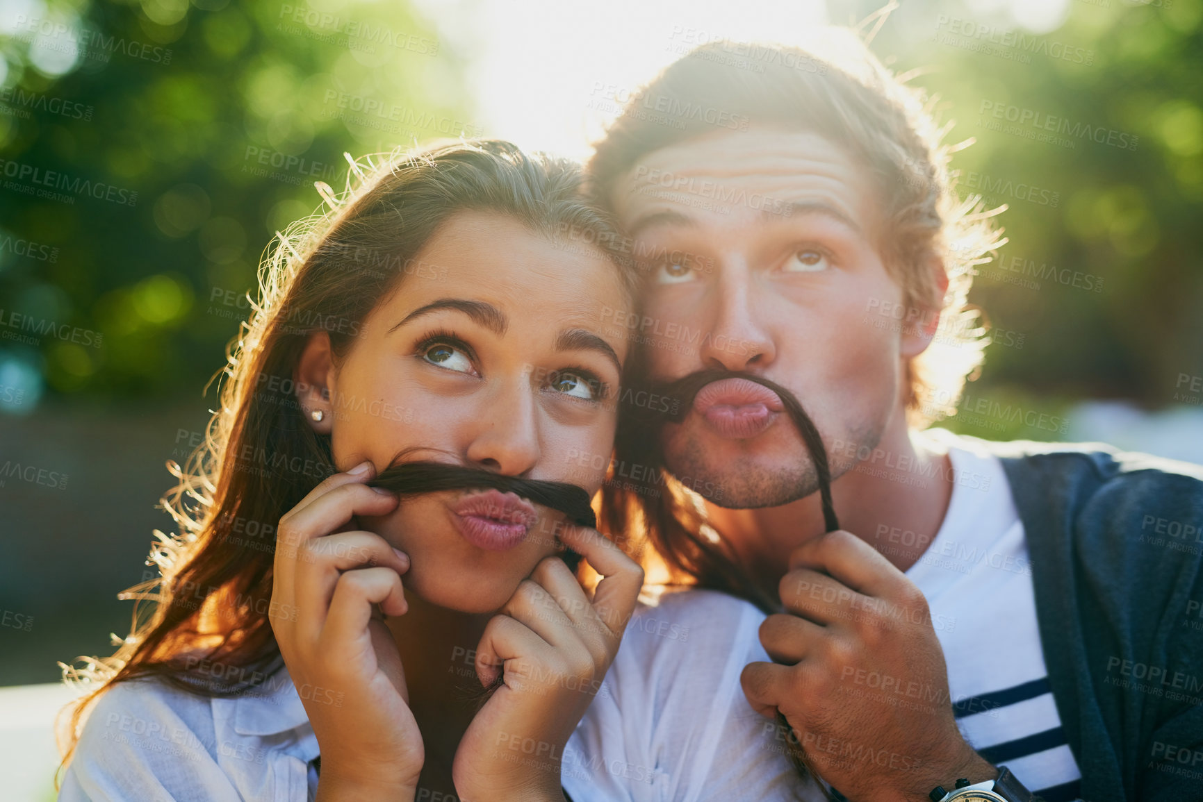 Buy stock photo Shot of a young couple enjoying a silly moment together while bonding outdoors