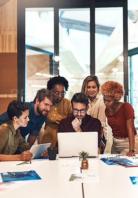 Buy stock photo Shot of a diverse group of businesspeople working together on a laptop in an office