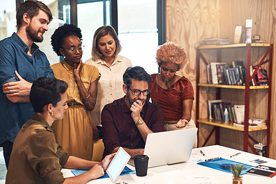 Buy stock photo Shot of a diverse group of businesspeople working together on a laptop in an office