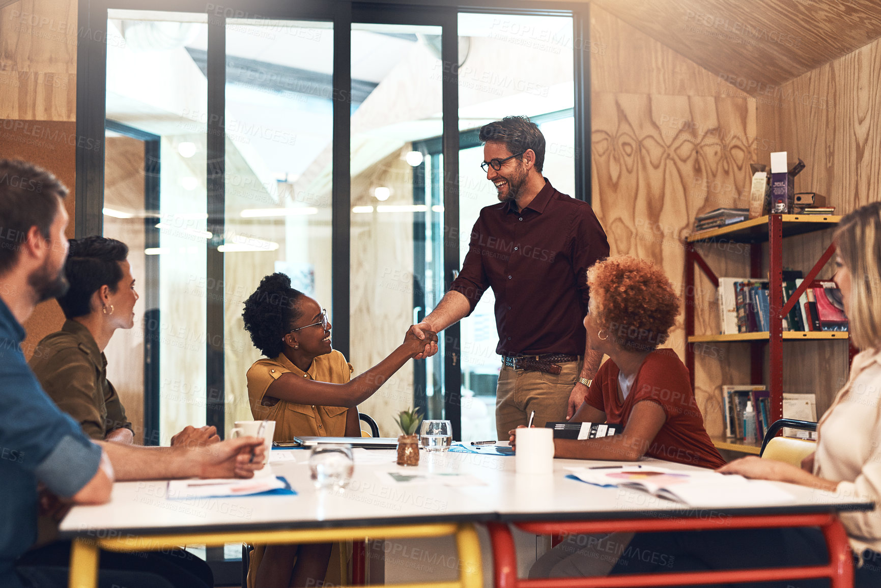 Buy stock photo Shot of businesspeople shaking hands during a meeting in an office