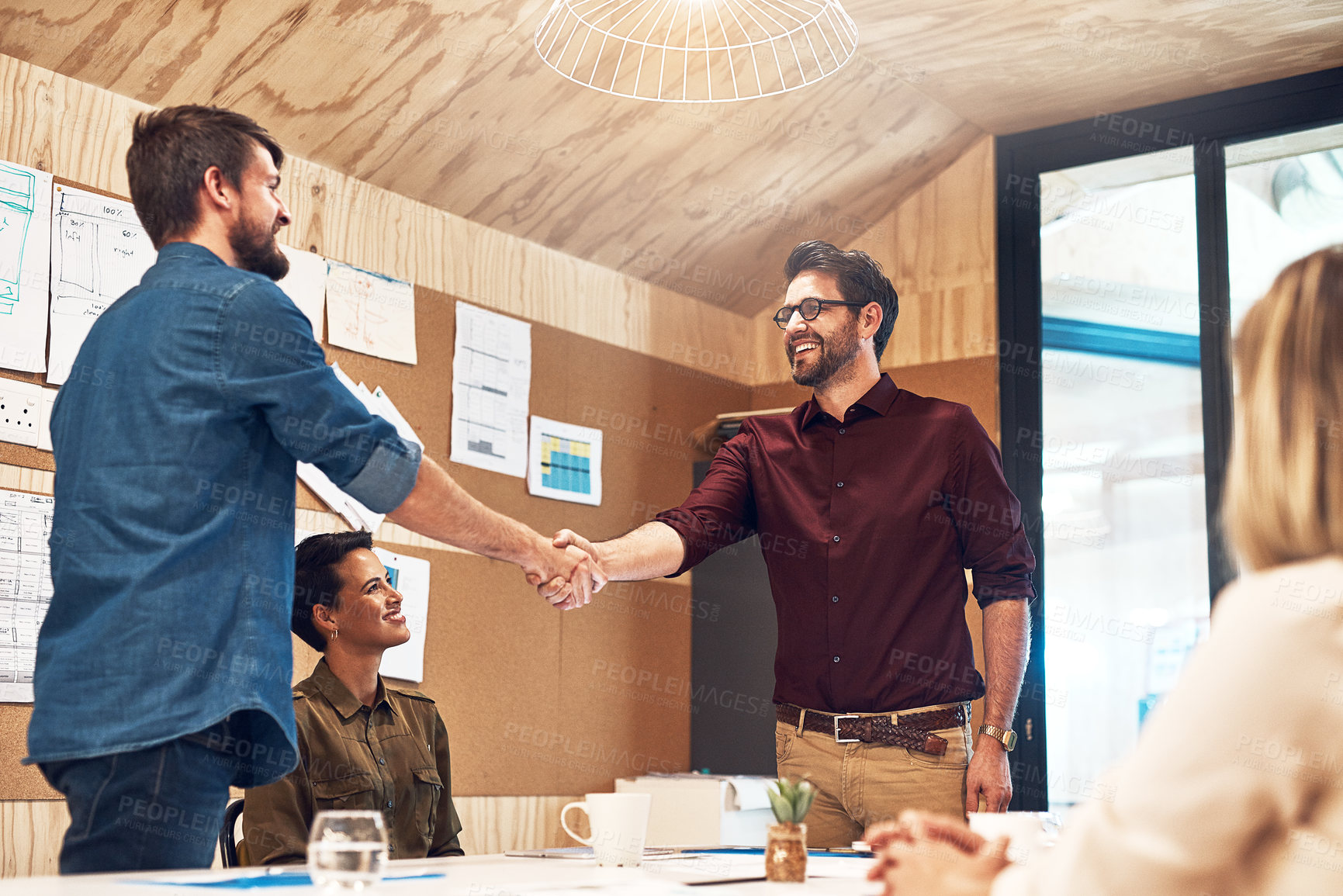 Buy stock photo Shot of businesspeople shaking hands during a meeting in an office