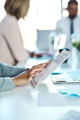 Buy stock photo Shot of an unrecognisable businessperson using a digital tablet in an office