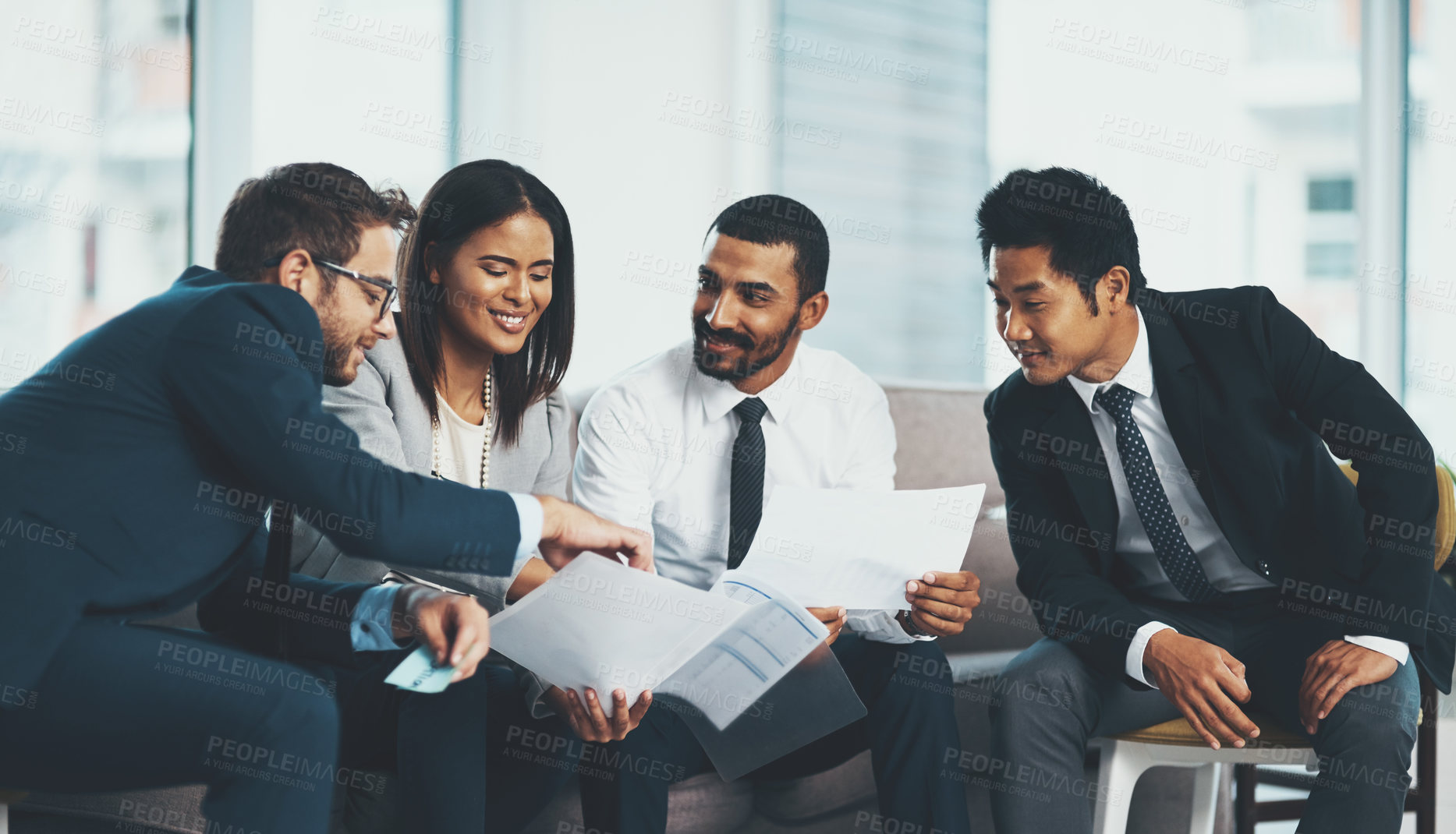 Buy stock photo Shot of a group of businesspeople discussing paperwork while sitting together