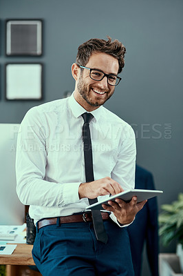 Buy stock photo Portrait of a young businessman using a digital tablet in an office