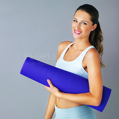 Buy stock photo Cropped portrait of an attractive and sporty young woman carrying her yoga mat against a grey background