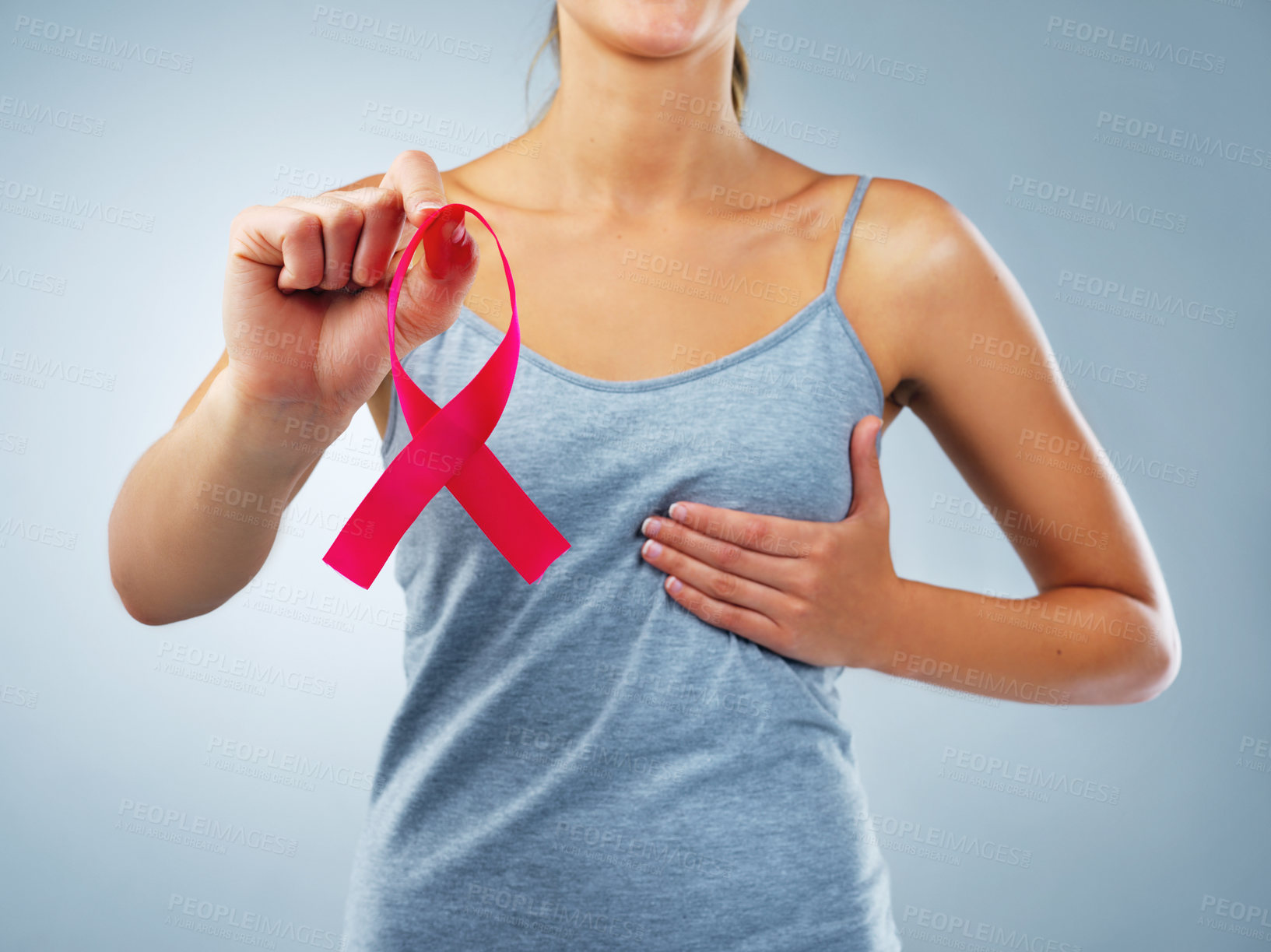 Buy stock photo Hands, woman and ribbon in studio for breast cancer with awareness, support or touch chest by blue background. Person, pink fabric and sign for call to action, test or check for wellness with empathy