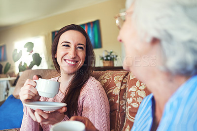 Buy stock photo Cropped shot of a senior woman and her granddaughter drinking a cup of tea at home