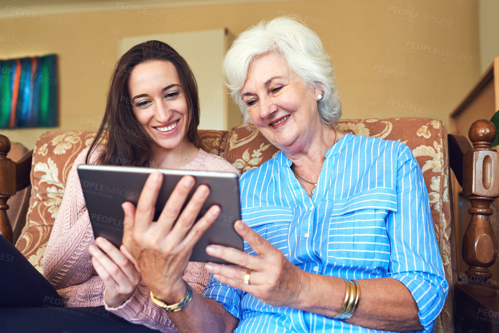 Buy stock photo Senior woman, daughter and tablet on couch for streaming, internet and video call in home living room. Elderly person, love and smile on sofa with helping hand for tech savvy, app or communication